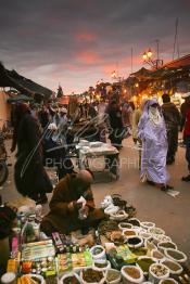 Image du Maroc Professionnelle de  Un Heboriste étale ses produits constitués d'épices, de graines et d'herbes de toutes sorte à même le sol de la fameuse place Jemaa El Fana de Marrakech, la ville touristique du Maroc, le 1er Mars 2004. (Photo / Abdeljalil Bounhar)